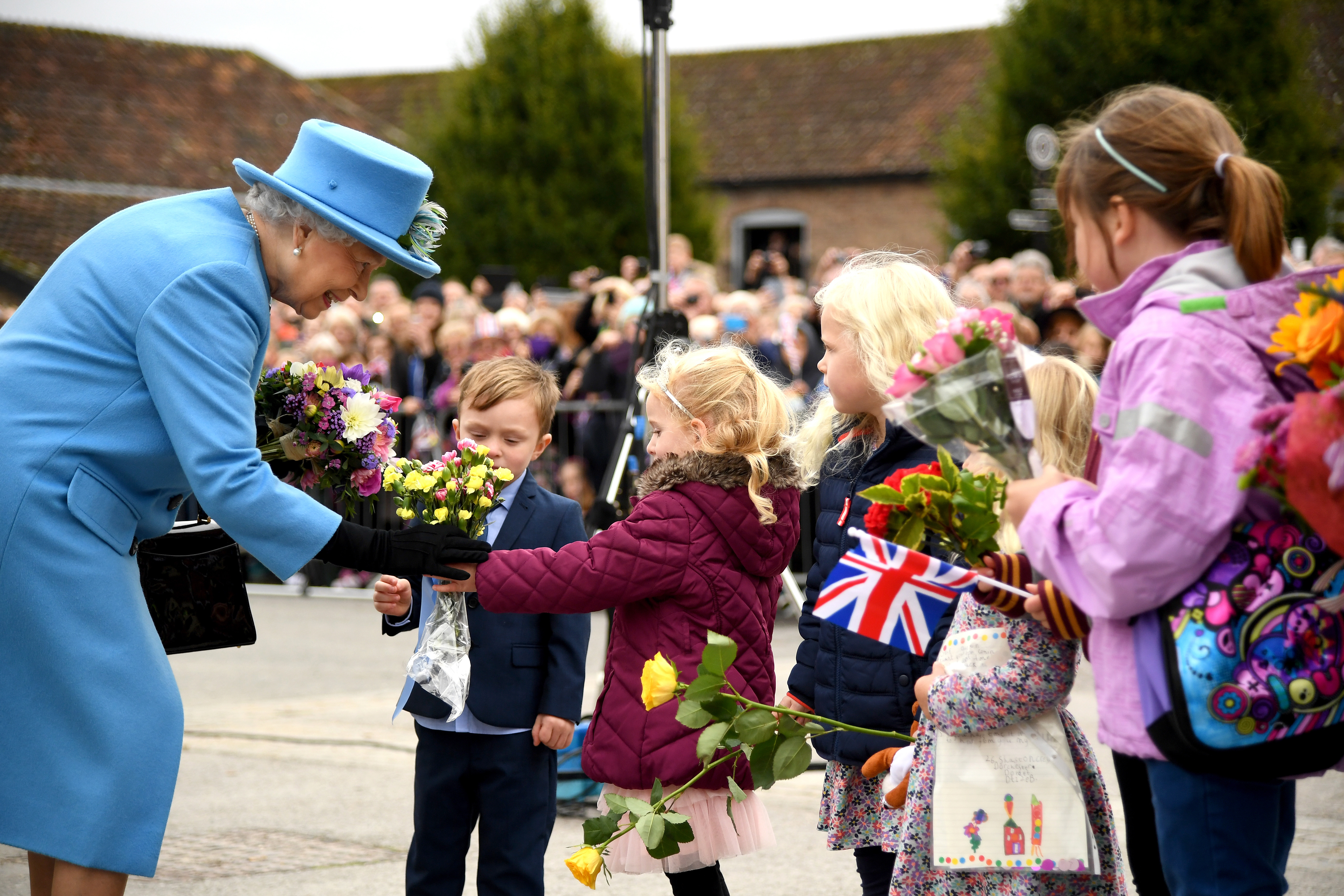 HRH The Queen at the unveiling of Queen Mother Square in Poundbury, accepting flowers from local children. 