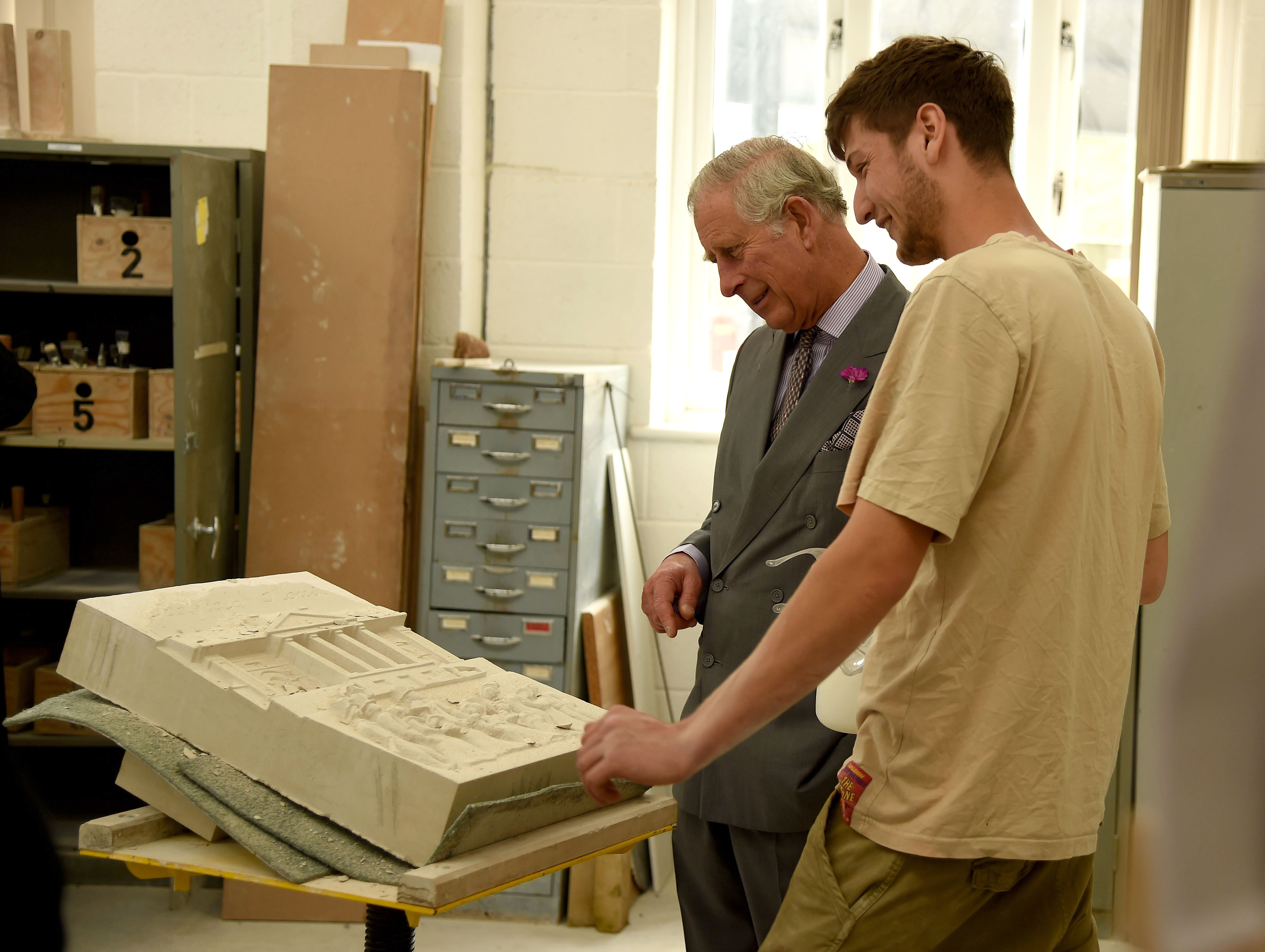 A stonemasonry student showing HRH The Prince of Wales his work during a Royal visit